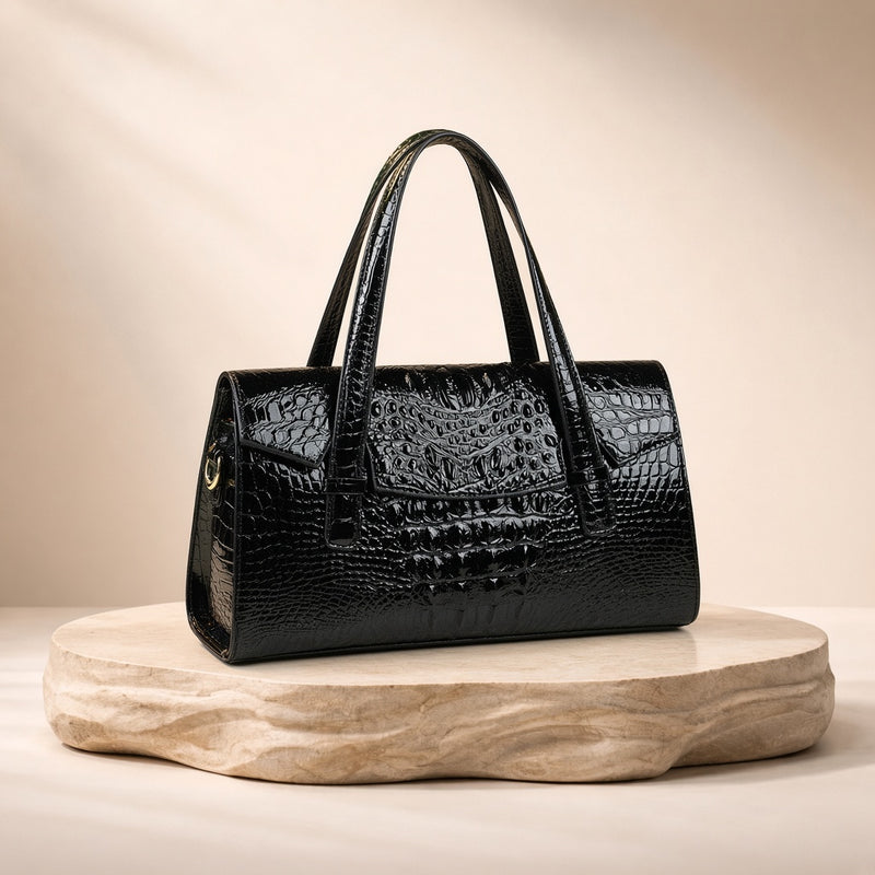 Sac Boston effet croco noir, posé sur un socle en pierre, vue produit
