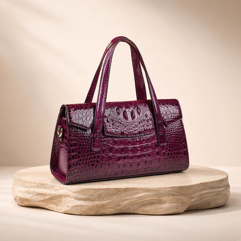 Sac Boston effet croco violet, posé sur un socle en pierre, vue produit
