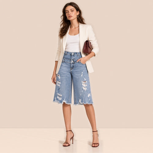Bermuda en jean bleu délavé à double ceinture et déchirures porté de face avec blazer ivoire et talons
