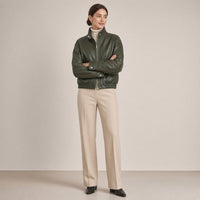 Blouson court en cuir de mouton à col montant vert olive foncé porté, bras croisés