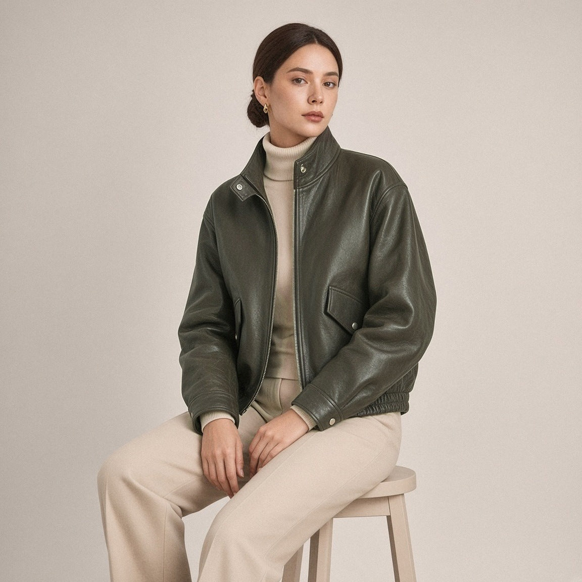 Blouson court en cuir de mouton à col montant vert olive foncé porté, assise