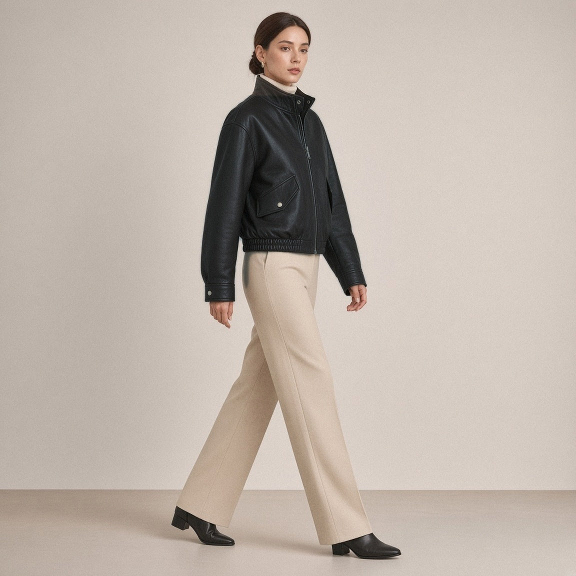 Blouson court en cuir de mouton à col montant noir porté, vue de profil en marche