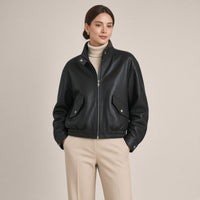 Blouson court en cuir de mouton à col montant noir porté, mains dans les poches