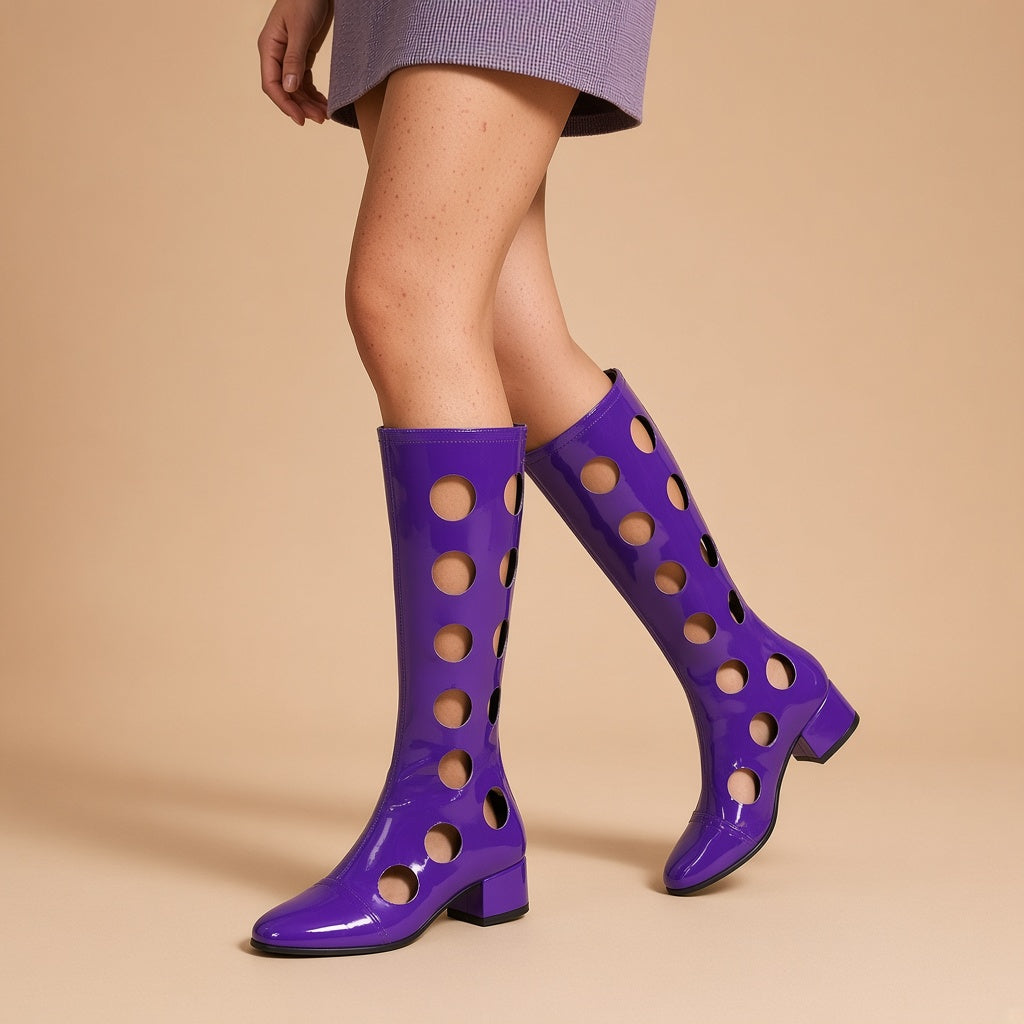 Bottes hautes ajourées effet vinyle violettes portées, vue des jambes sur fond beige