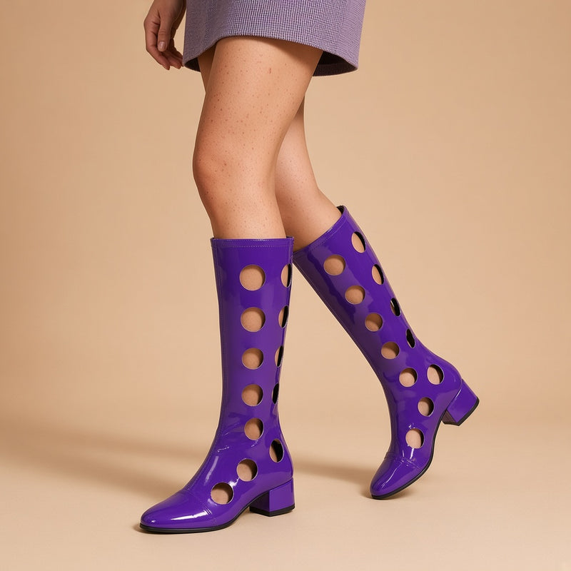 Bottes hautes ajourées effet vinyle violettes portées, vue des jambes sur fond beige