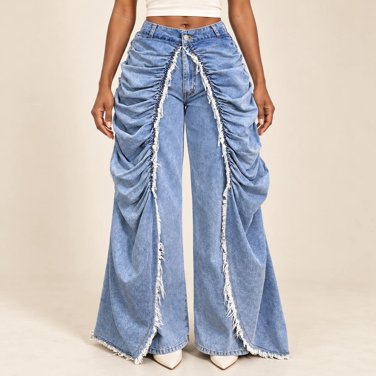 Détail du jean bleu : fronces, panneaux drapés et franges longues