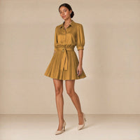 Ensemble chemise à manches bouffantes et jupe courte plissée ceinturée, moutarde, portée en marchant