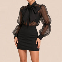 Jupe crayon noire taille haute à bouton devant, portée avec la chemise à nœud et manches bouffantes