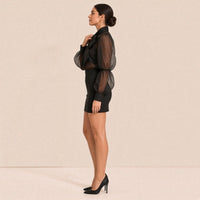 Ensemble noir vu de profil : manche bouffante froncée à large poignet et jupe crayon mi-cuisse