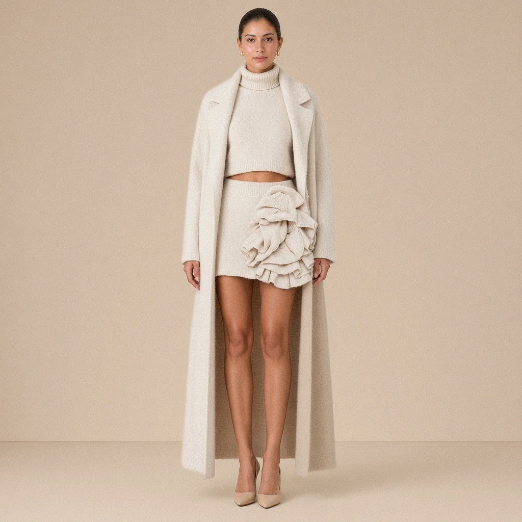 Ensemble trois pièces en maille : manteau long, col roulé et jupe à volants, beige avoine, porté de face en pied