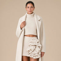 Ensemble trois pièces en maille : manteau long, col roulé et jupe à volants, beige avoine, détail du col roulé et des revers