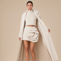 Ensemble trois pièces en maille : manteau long, col roulé et jupe à volants, beige avoine, détail de la cascade de volants