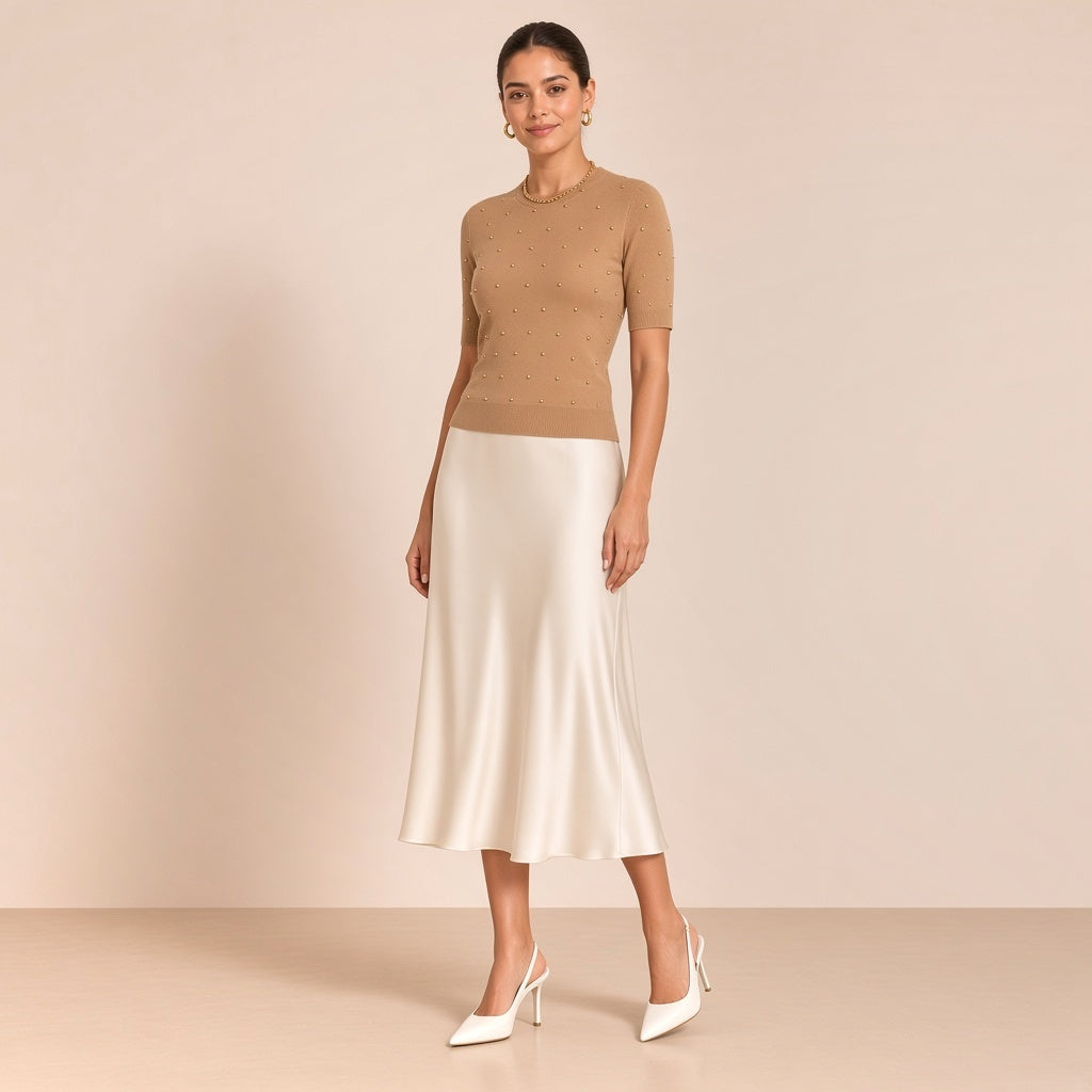 Escarpins slingback blancs à bout pointu SAKIWE portés avec une jupe midi satinée ivoire, en pied sur fond beige