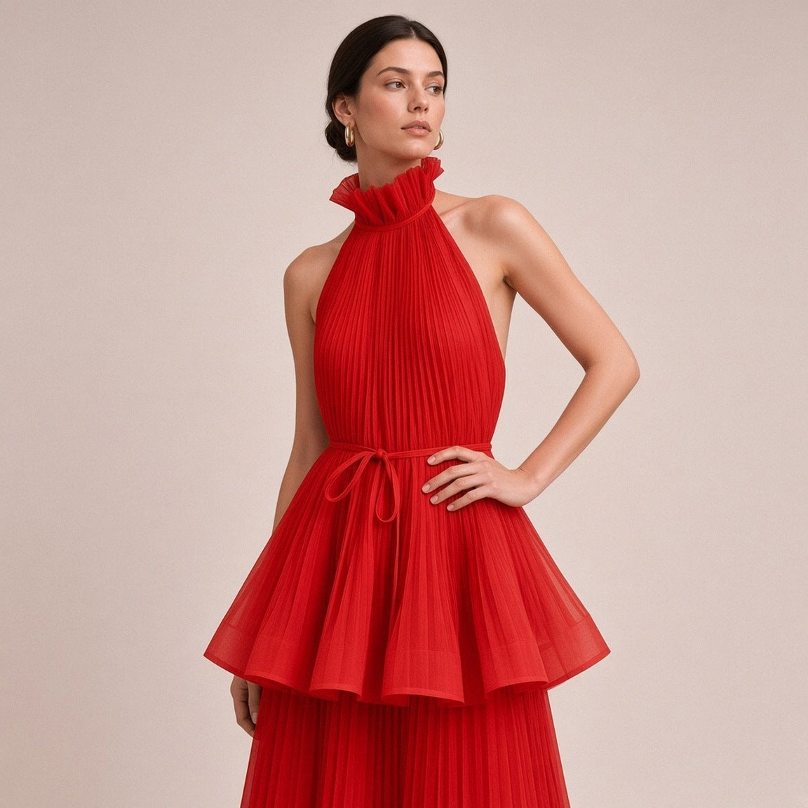 Robe longue plissée SAKIWE rouge portée, en gros plan sur le col montant, la ceinture et la basque
