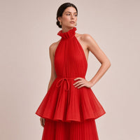 Robe longue plissée SAKIWE rouge portée, en gros plan sur le col montant, la ceinture et la basque