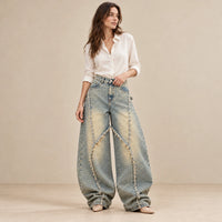 Jean baggy bleu vintage à coutures courbes effilochées, vue de face portée avec chemise ivoire