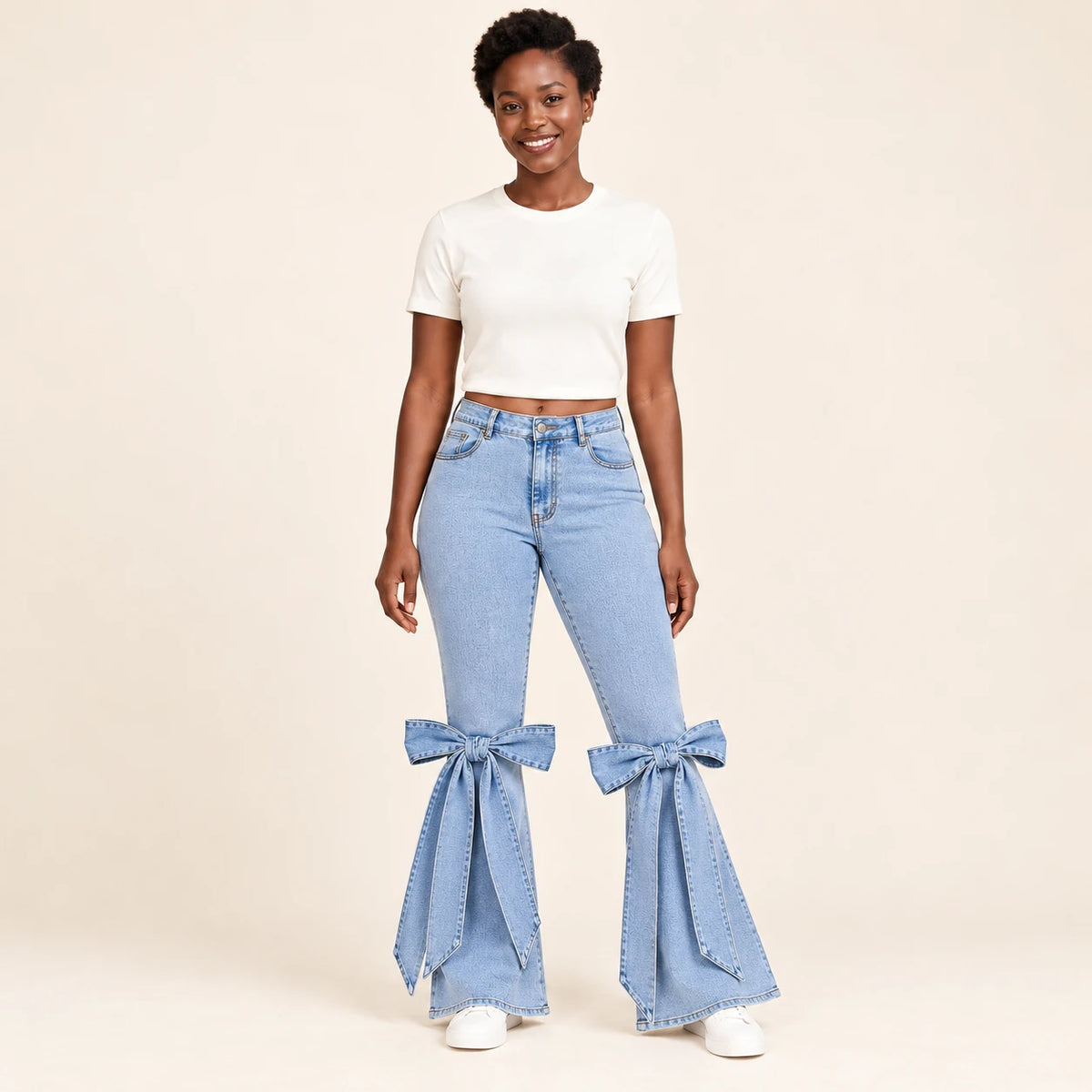 Détail de face des grands nœuds en denim noués aux chevilles du jean flare bleu clair