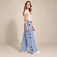 Jean large bleu clair à cœurs brodés, motif latéral vu de profil