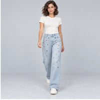 Jean large bleu clair avec ornements multicolores, pose en marche