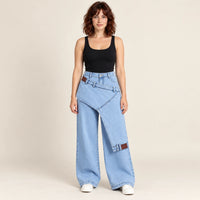 Jean large bleu clair à surpanneau asymétrique, vue de face sur mannequin SAKIWÉ