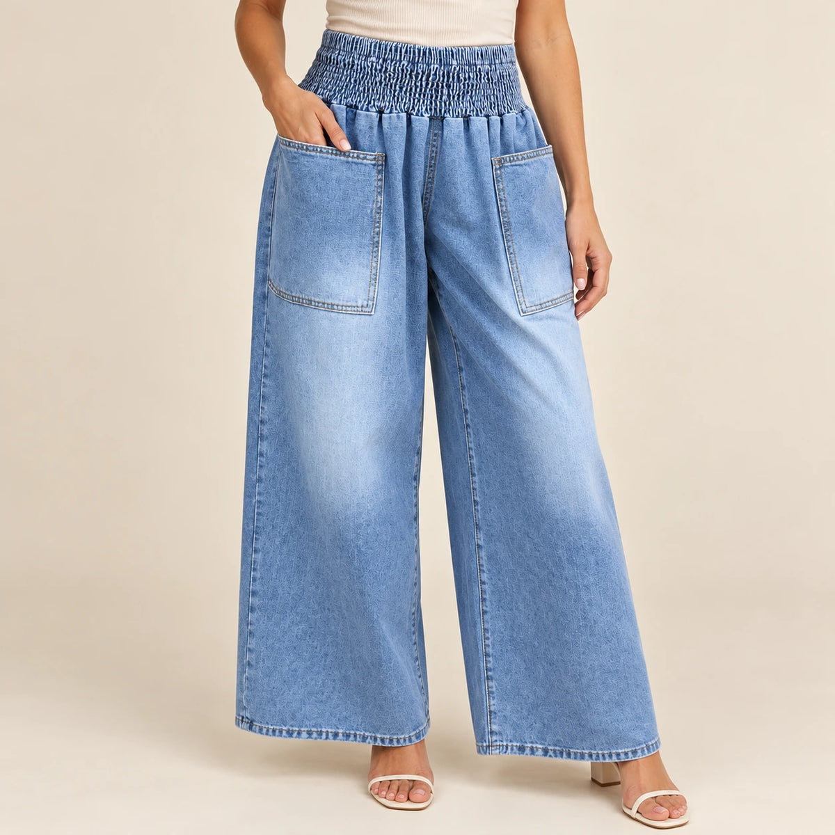 Détail du jean bleu : taille froncée et poches plaquées