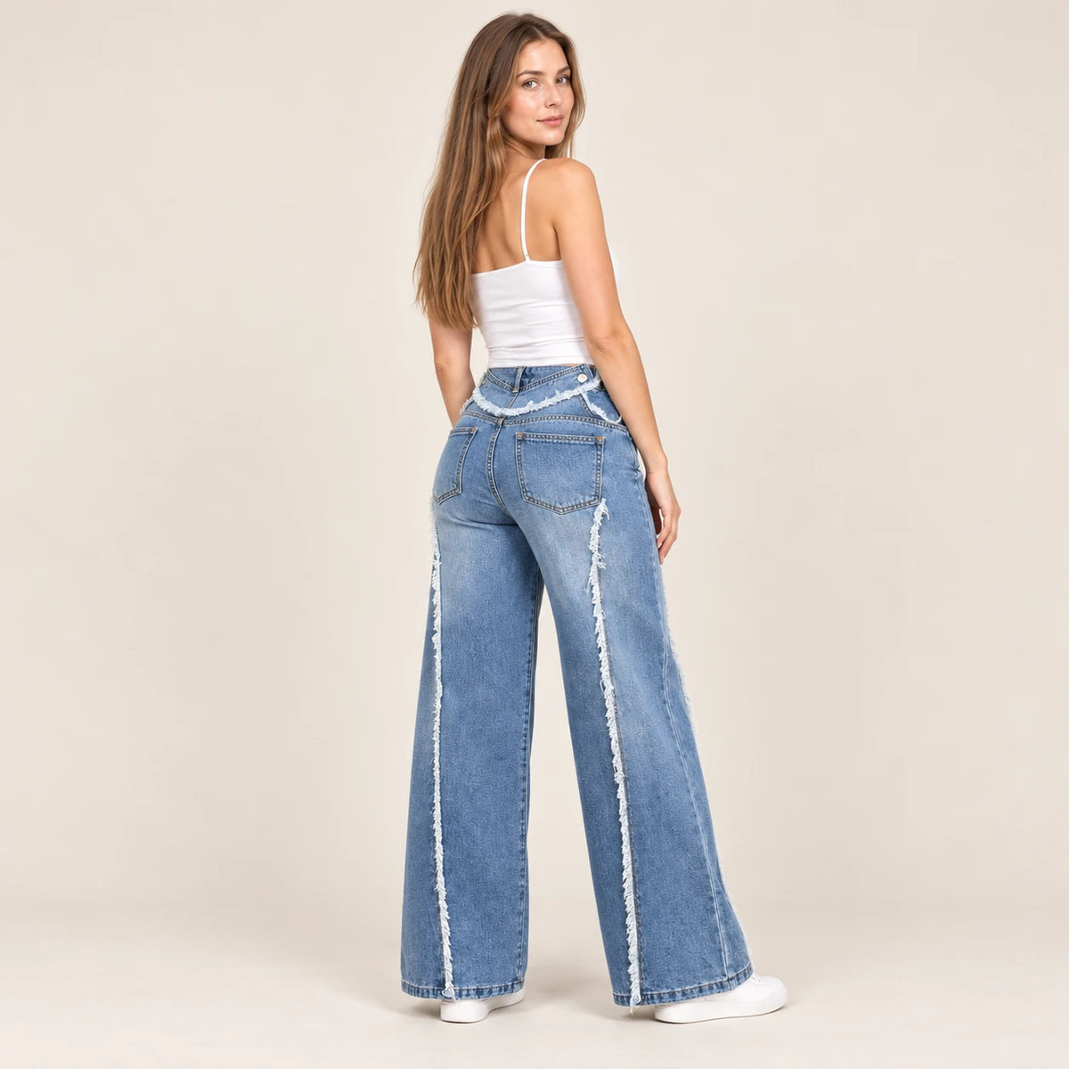 Vue arrière du jean large bleu avec coutures de panneaux effilochées