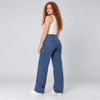 Vue arriére du jean large bleu à broderies papillons sur les jambes