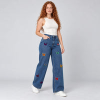 Vue trois quarts du jean bleu foncé à jambes larges brodé de papillons