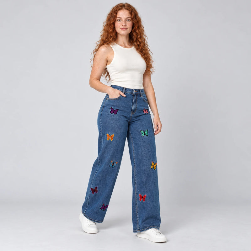 Vue trois quarts du jean bleu foncé à jambes larges brodé de papillons