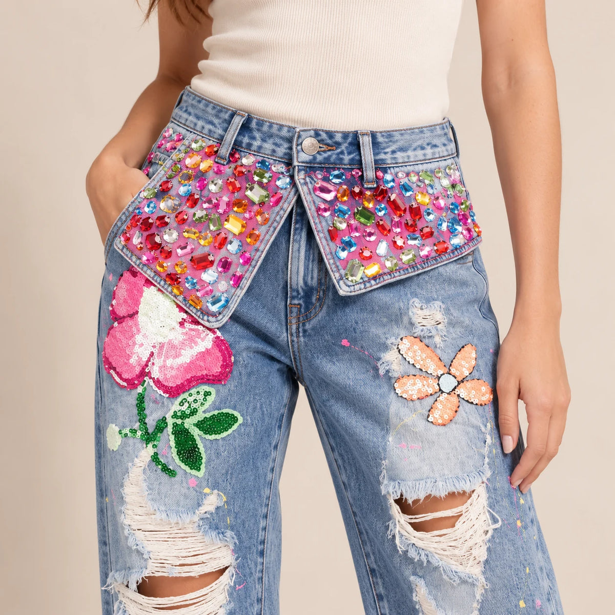 Détail des panneaux à strass et appliqués colorés du jean bleu clair