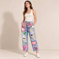 Jean large bleu clair orné de patchs et de strass multicolores, vue de face