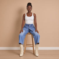 Jean large court bleu porté assise sur un tabouret – SAKIWÉ