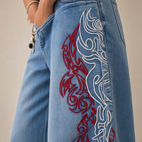 Détail de la broderie dragon rouge et blanche et du grain du denim – SAKIWÉ