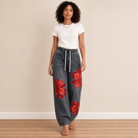 Jean large gris délavé à fleurs rouges, porté en marchant – SAKIWÉ
