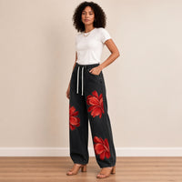 Jean large noir à fleurs rouges, vue de trois-quarts – SAKIWÉ