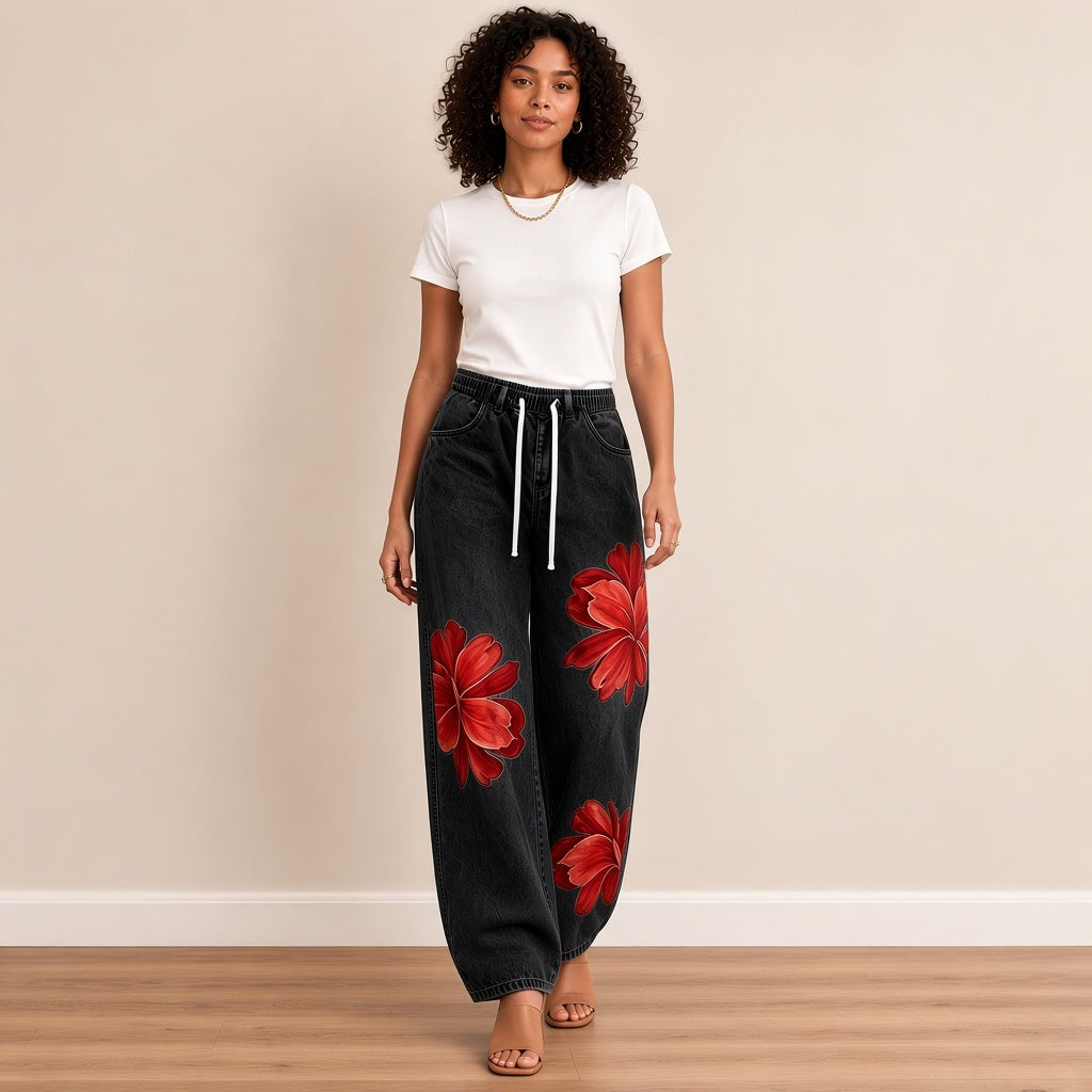 Jean large noir à fleurs rouges, porté en marchant – SAKIWÉ