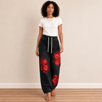 Jean large noir à fleurs rouges, porté en marchant – SAKIWÉ