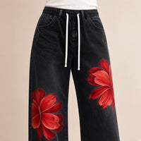 Jean large noir à fleurs rouges, détail taille à cordon et fleurs – SAKIWÉ