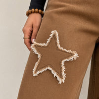 Détail d'une étoile effilochée et du grain du denim marron – SAKIWÉ