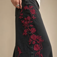 Détail de la broderie de roses rouges sur le jean noir délavé – SAKIWÉ