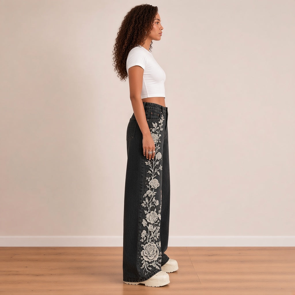 Jean large noir délavé, profil montrant la broderie de roses blanches le long de la jambe droite – SAKIWÉ