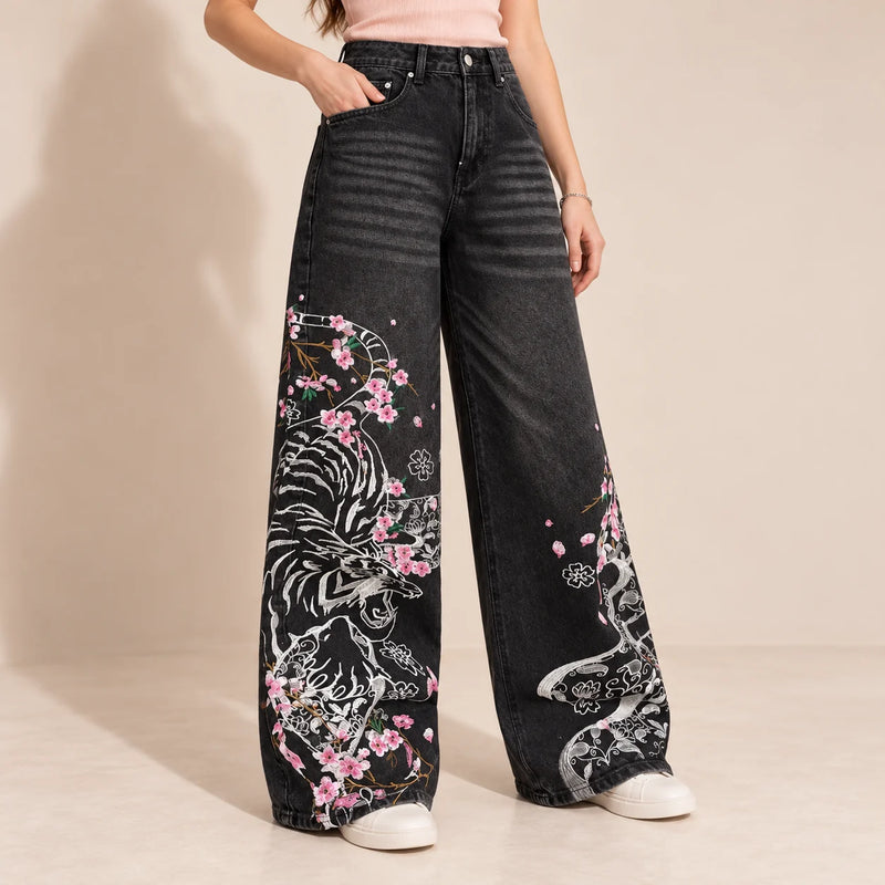 Détail du tigre blanc et des fleurs roses sur le jean noir grisé