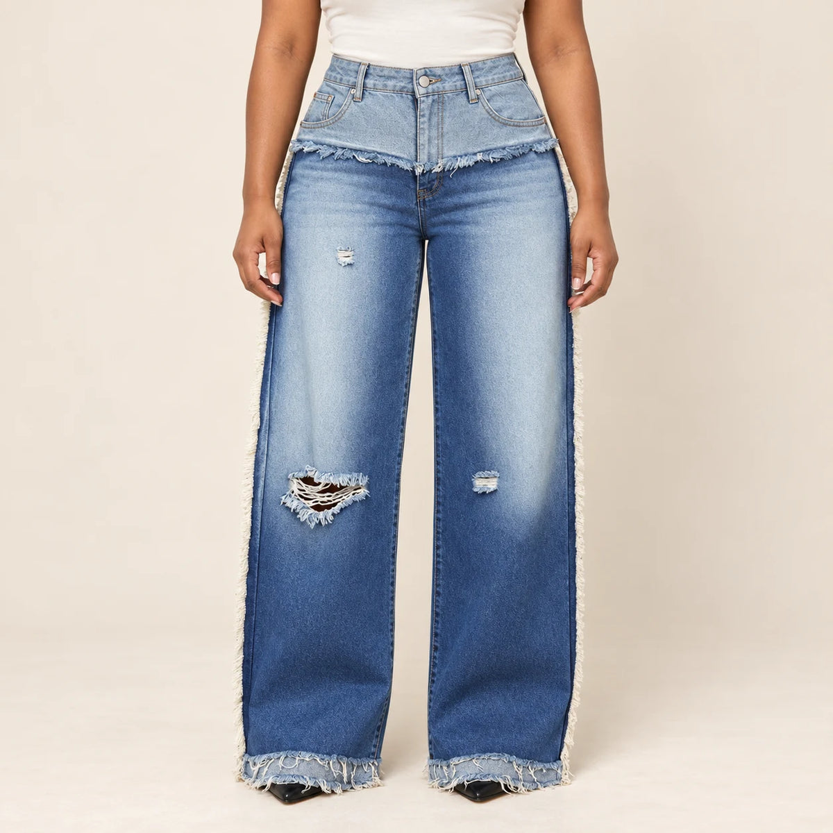 Détail du jean bleu : taille rabattue, franges et déchirures