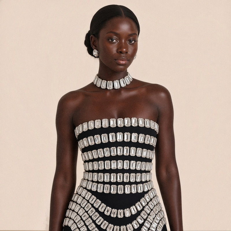 Gros plan du bustier droit et des rangs de cristaux de la mini robe noire SAKIWE