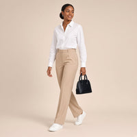 Femme marchant, mini sac bowling en cuir effet croco noir tenu à la main par ses anses