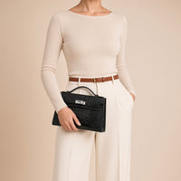 Pochette en cuir effet croco SAKIWE noir, détail porté, glissée sous le bras