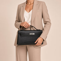 Gros plan sur la pochette en cuir croco mat SAKIWE noir et son fermoir serti de strass