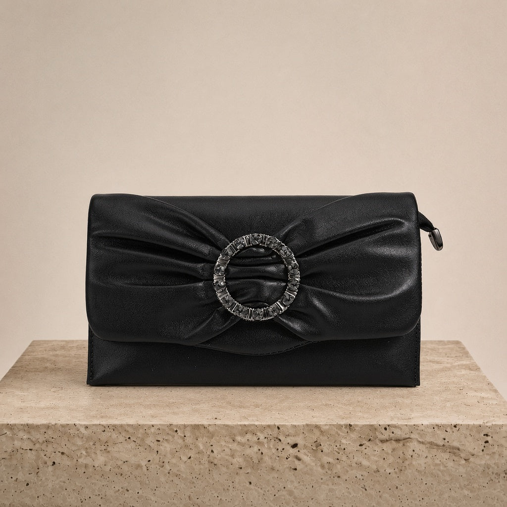 Pochette froncée en cuir SAKIWE noir posée sur un socle en pierre