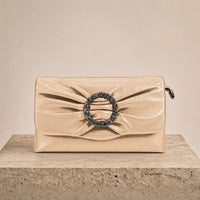 Pochette froncée en cuir SAKIWE champagne posée sur un socle en pierre