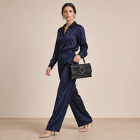 Pochette froncée en cuir SAKIWE noir portée au poignet avec la dragonne